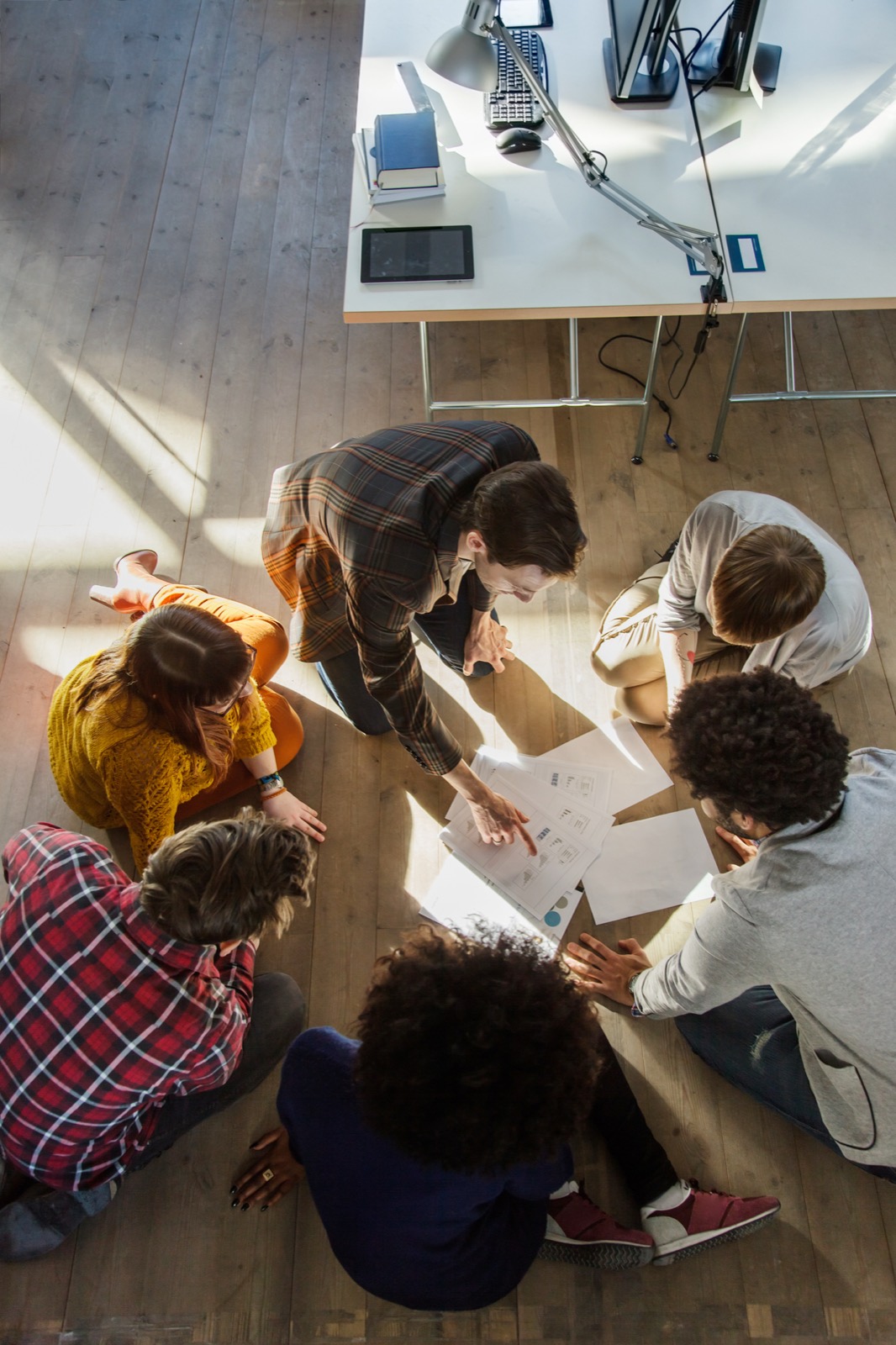 Des participants travaillent ensemble au sol sur de grandes feuilles
